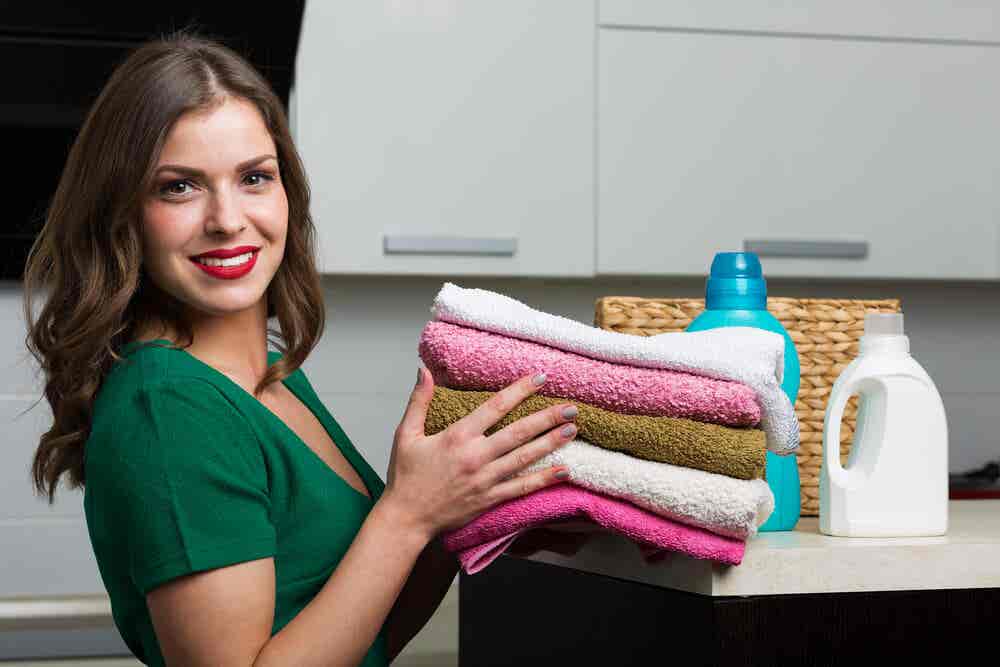 Mujer sosteniendo toallas limpias y dobladas.