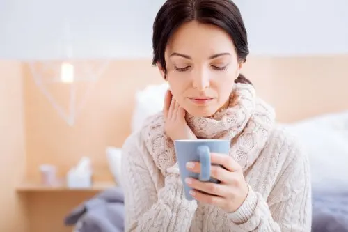 Mujer con una bufanda y una taza en la mano