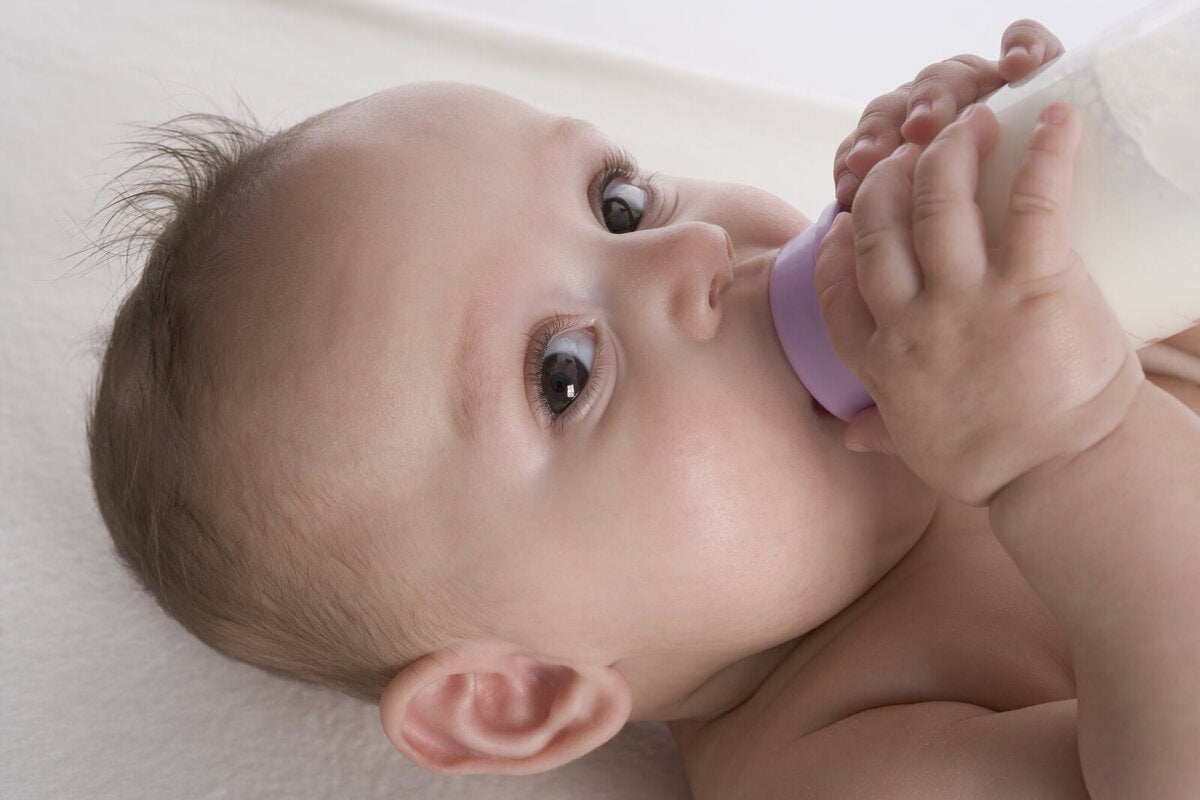 Un niño recién nacido bebe leche de un biberón con chupete. concepto de  alimentación saludable y lactancia.