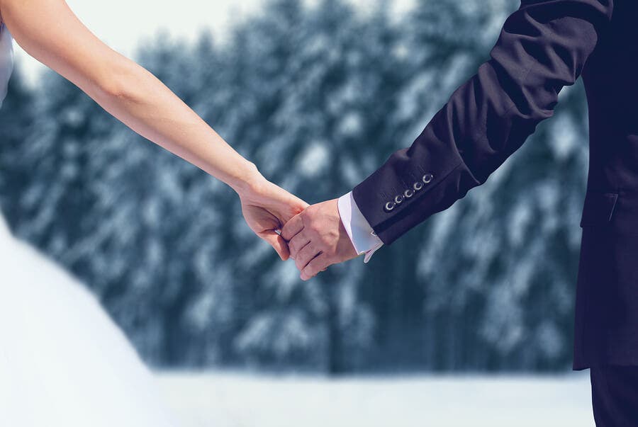 Pareja cogidos de la mano en invierno.