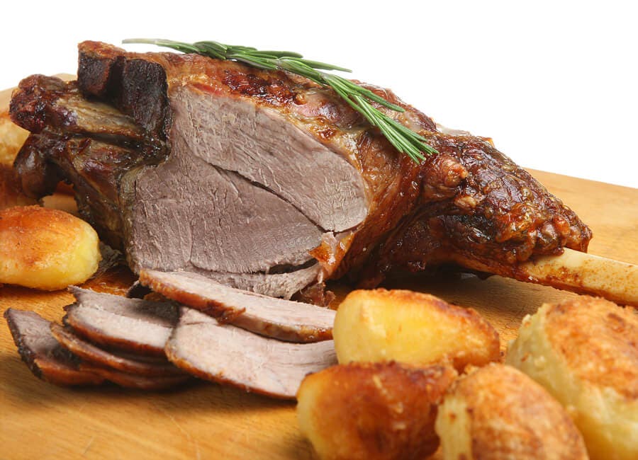 Trozo de cordero asado con patatas.