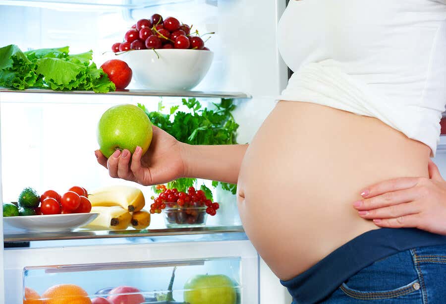 Embarazada en nevera con fruta, agregar más frutas a la dieta