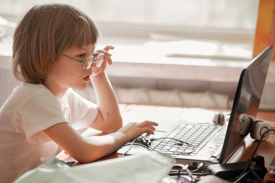 Niña con gafas usando ordenador