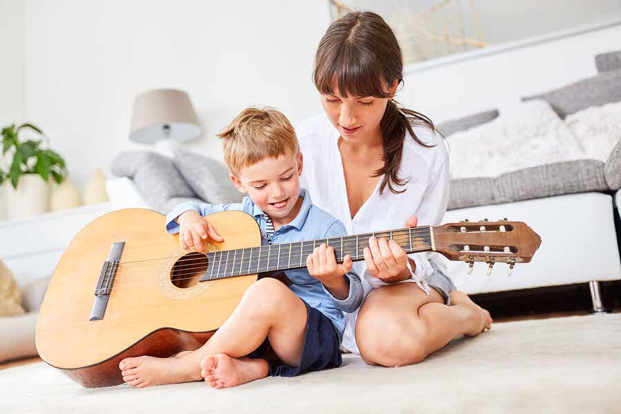 Niño aprende a tocar la guitarra.