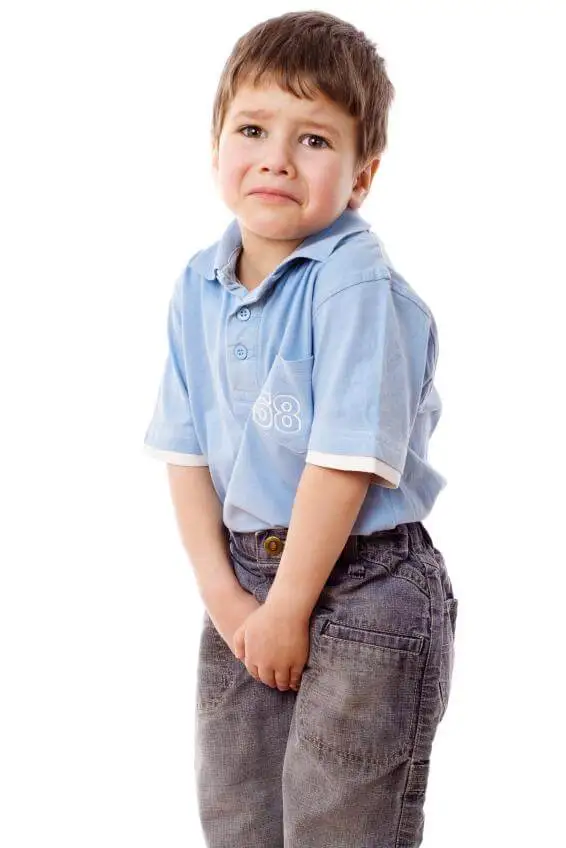 Niño preocupado con las manos en el pantalón.