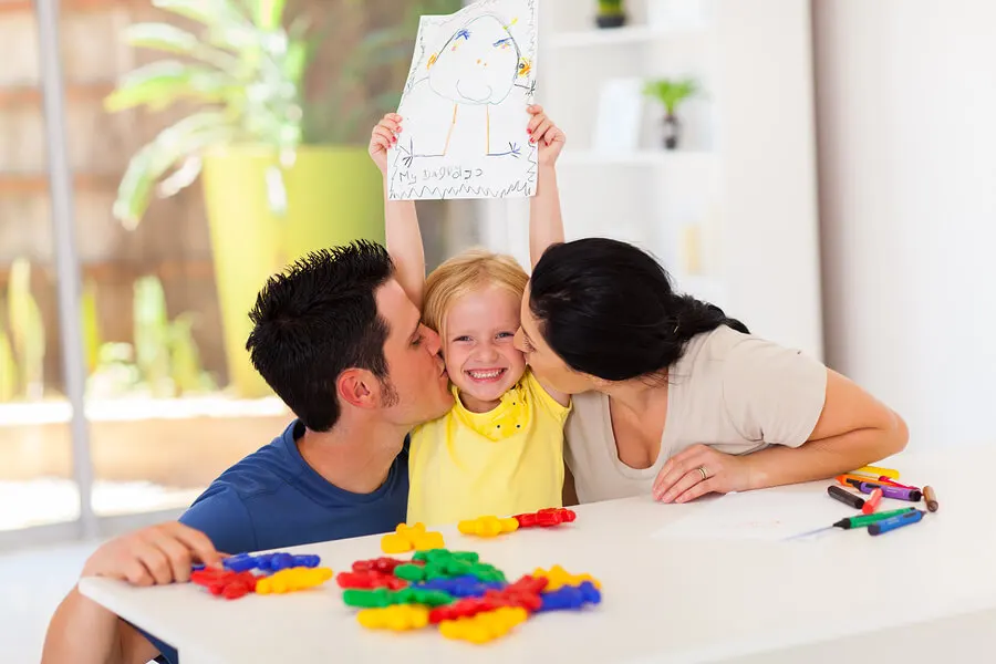 Padres besando a su hija