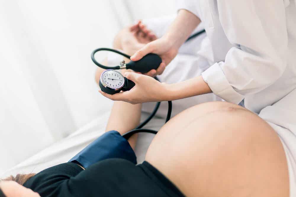 Mujer embarazada midiéndose la presión arterial