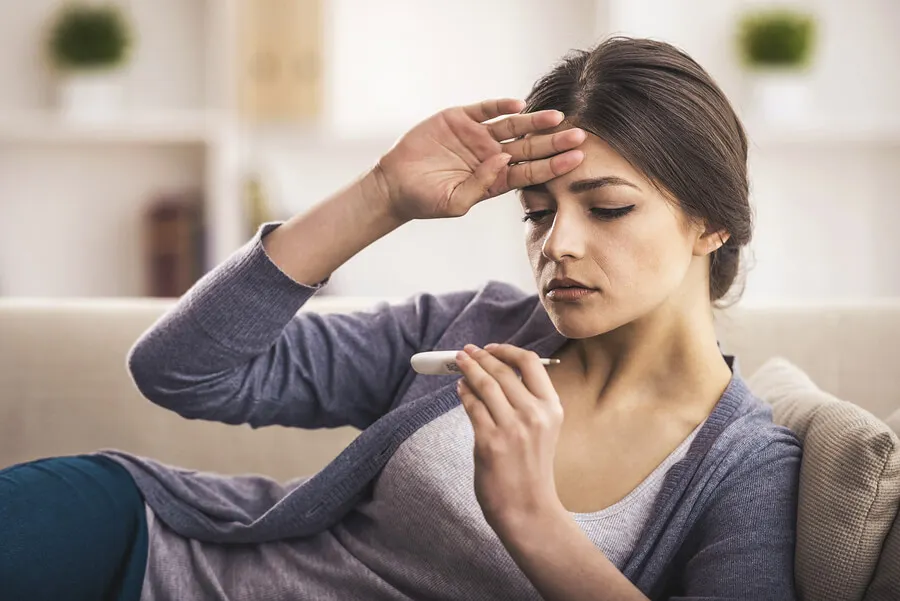 Mujer tumbada con la mano en la frente.