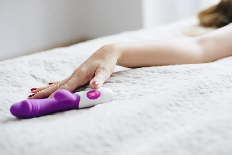Brazo de mujer cerca de un dildo.