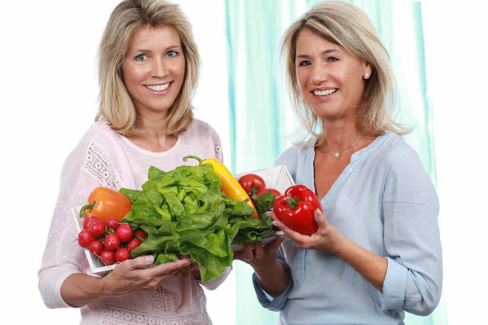 Dos mujeres con verduras en la mano.