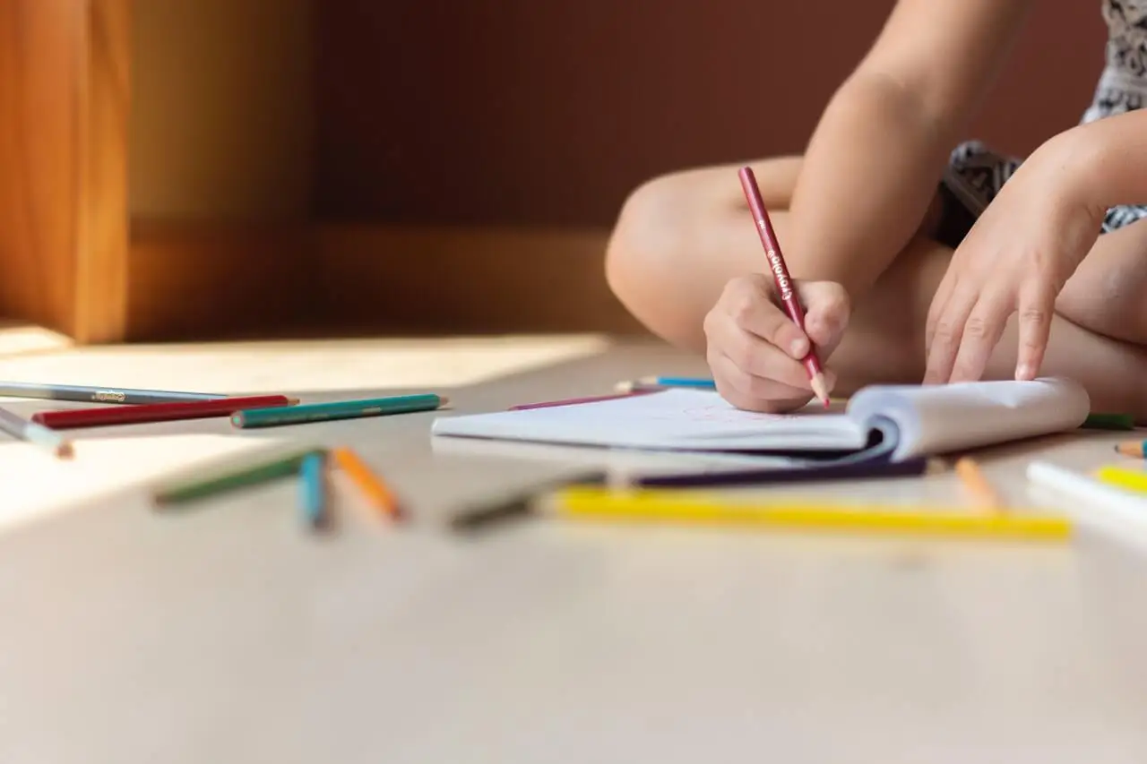 Niña coloreando en su libreta.