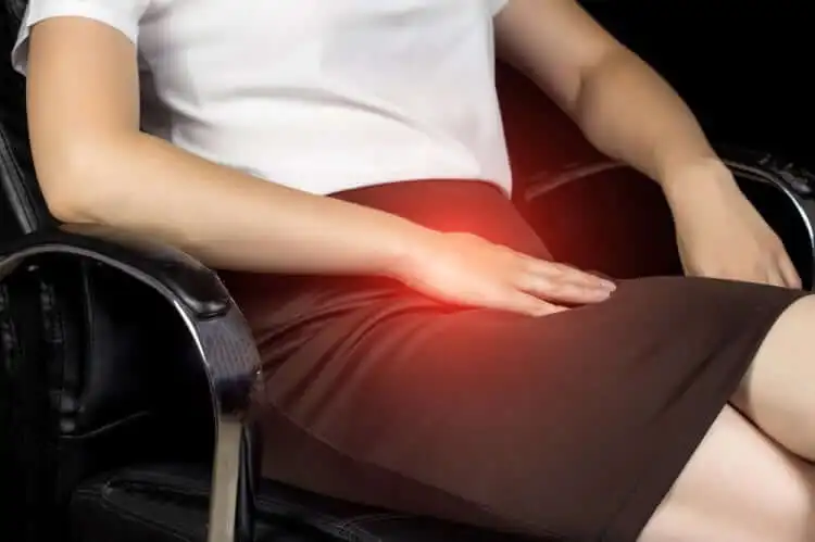 Mujer sentada con dolor en la ingle