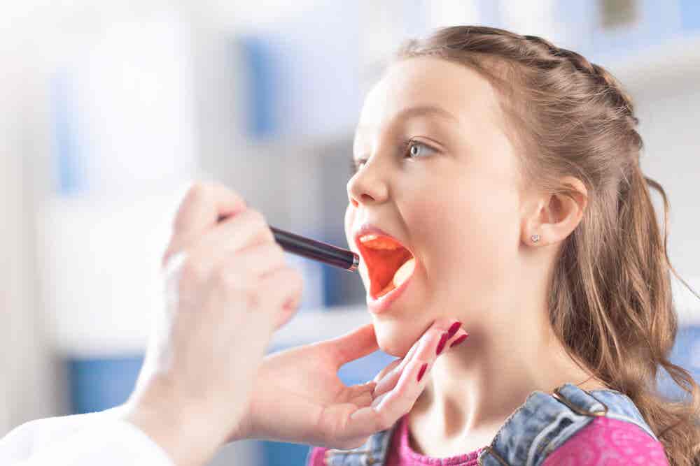 médico examinando la garganta de una niña