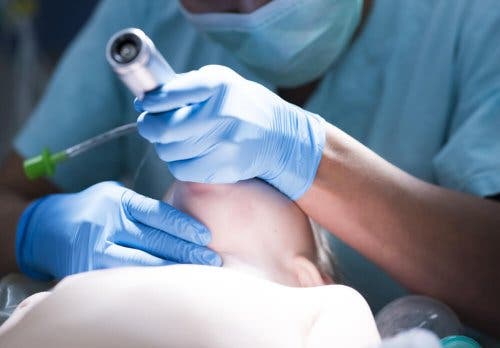 Médico intubando a un niño: inducción de rápida secuencia