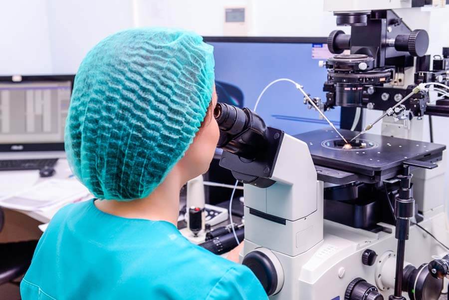 Mujer observando por el microscopio