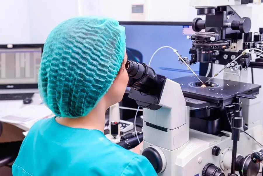 Mujer observando por el microscopio