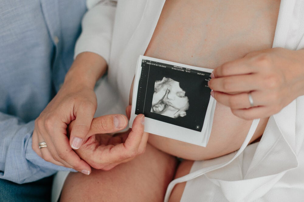Médica realizando ecografía abdominal a una embarazada