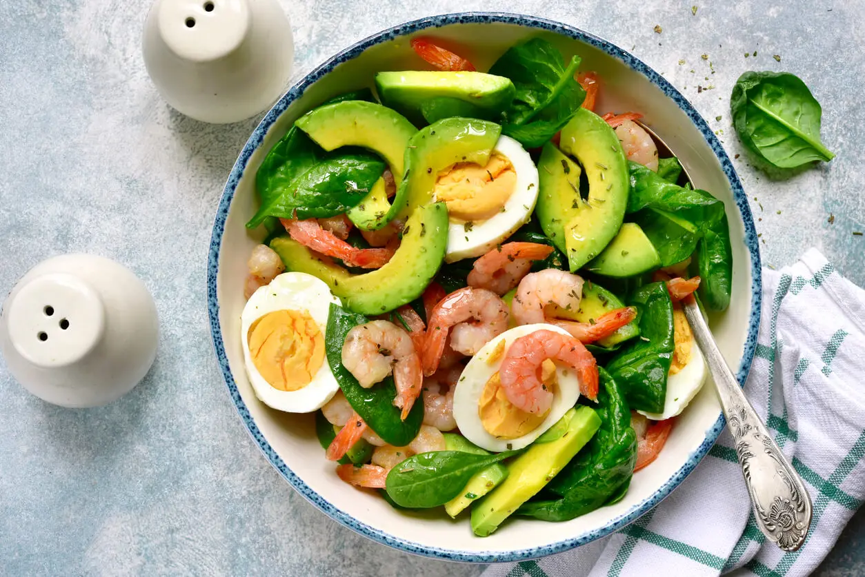 Plato de ensalada de aguacate, gambas y huevo duro.