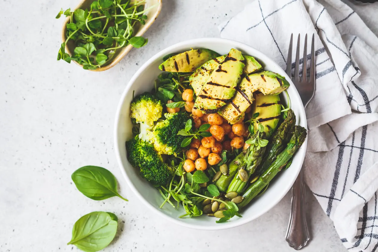 Bol de ensalada con verduras, garbanzos y aguacate.