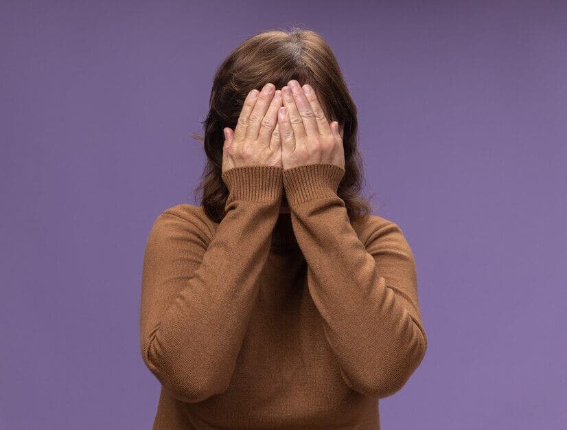 Mujer con las manos en la cara.