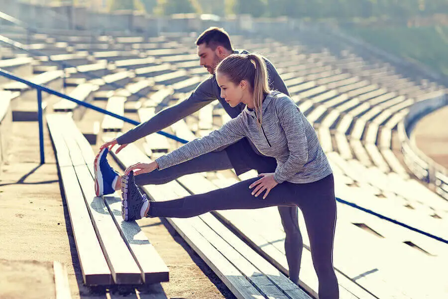 Pareja estirando para salir a correr.
