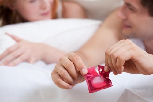 Pareja abriendo un preservativo en caso de herpes genital