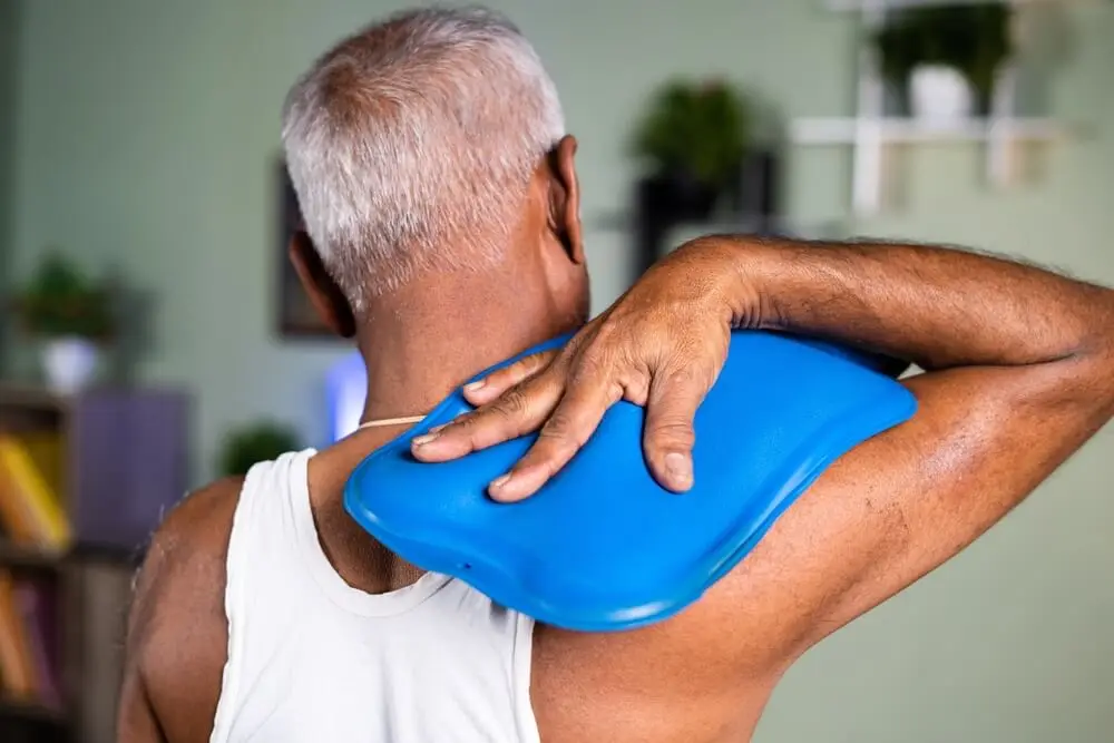 Hombre con artritis se aplica calor