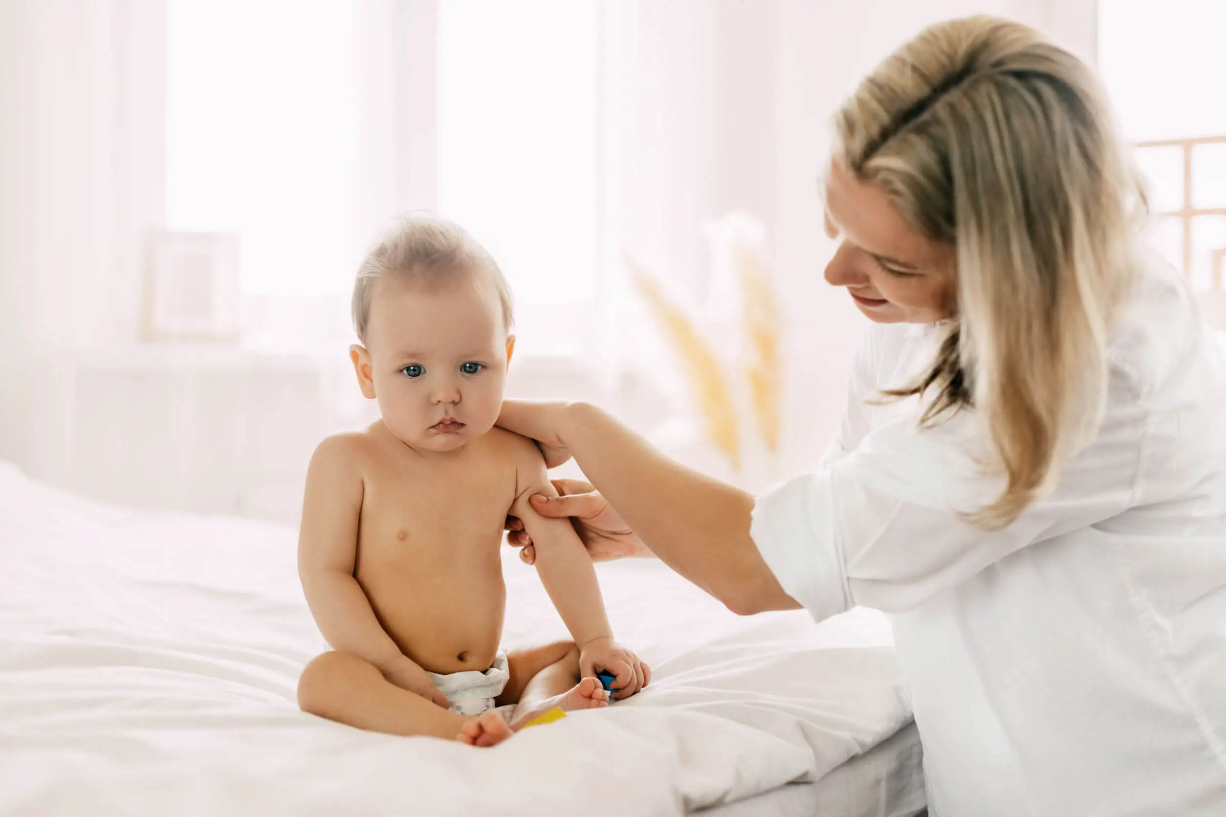 Medico esegue diagnosi di ipotonia muscolare nel bambino.