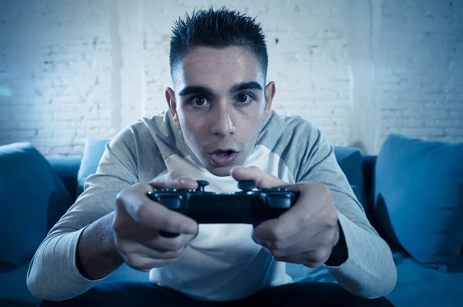 Adolescente jugando videojuegos.