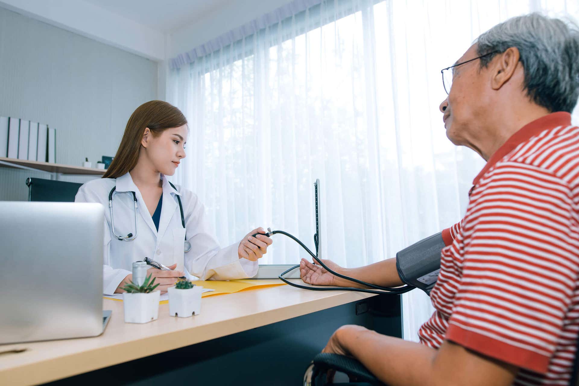 Calcitriol - Ärztin misst bei einem Patienten den Blutdruck