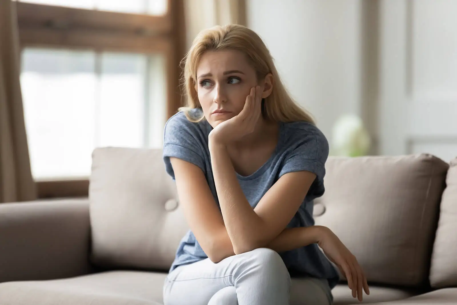 Mujer sentada con pensamientos negativos.