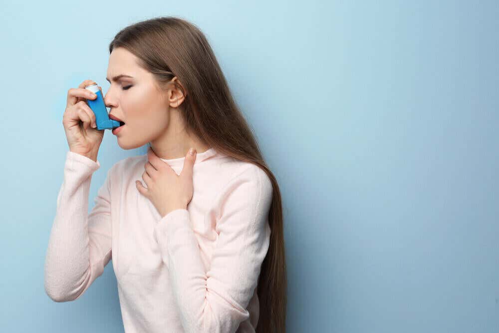 Mujer usando inhalador para el asma.