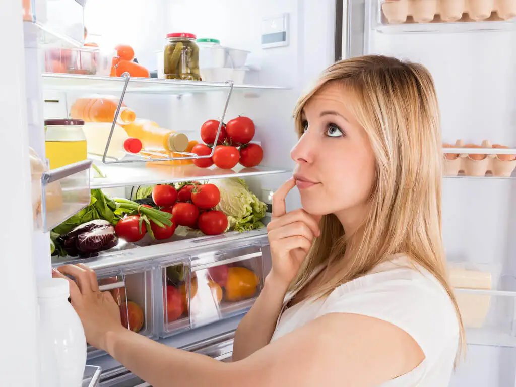 Frau vor dem Kühlschrank