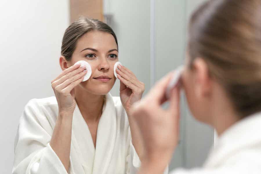 Mujer limpiando su cara para tener una piel radiante