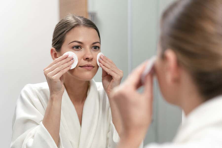 Женщина очищает лицо, чтобы иметь сияющую кожу