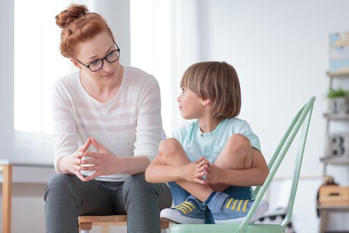 Mujer hablando con niño después del colegio.
