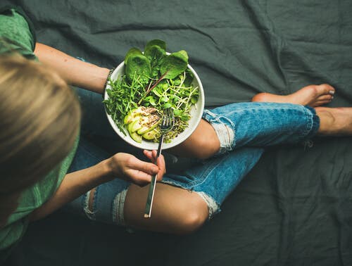 Mujer comiendo sano para tener una menstruación menos dolorosa