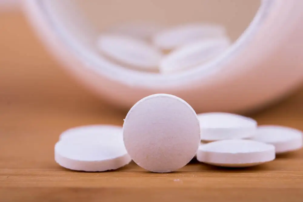 Pastillas de paracetamol saliendo de un frasco.