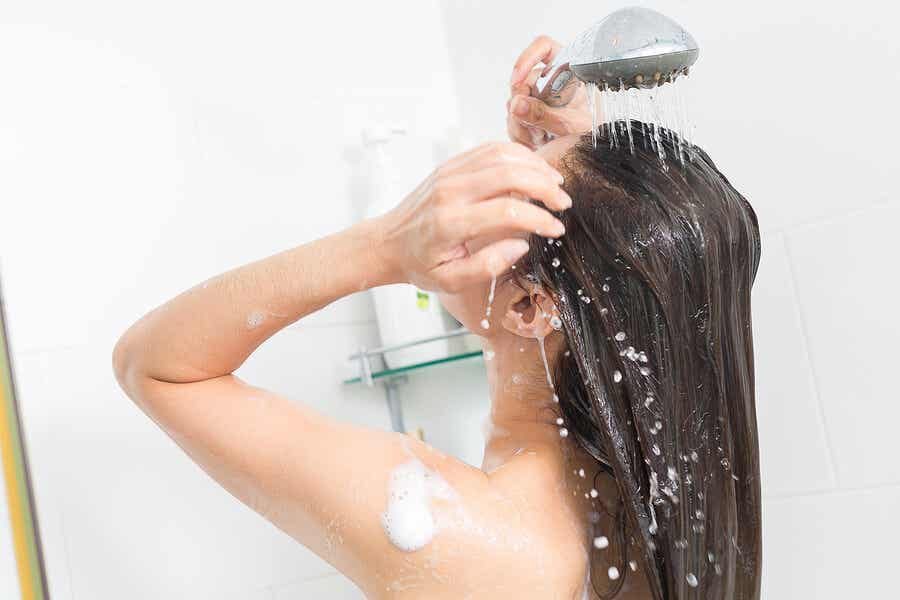 Mujer tomando ducha con agua caliente