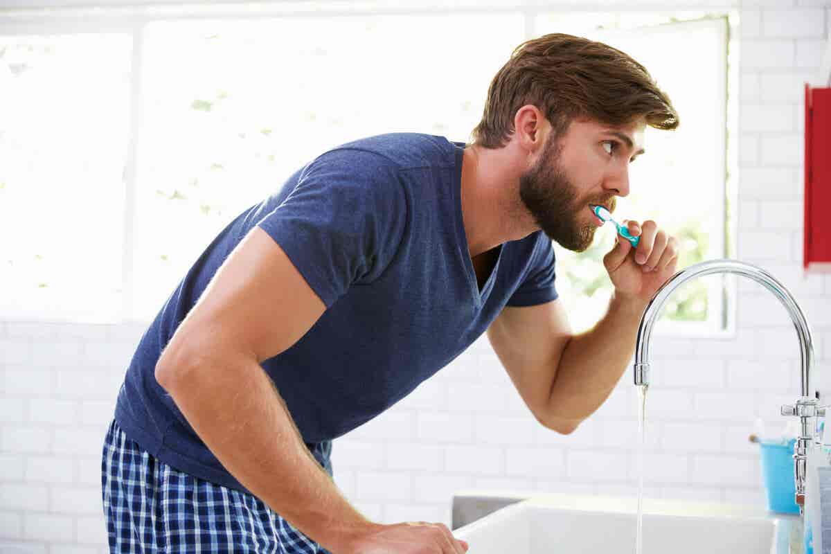 Hombre cepilla sus dientes