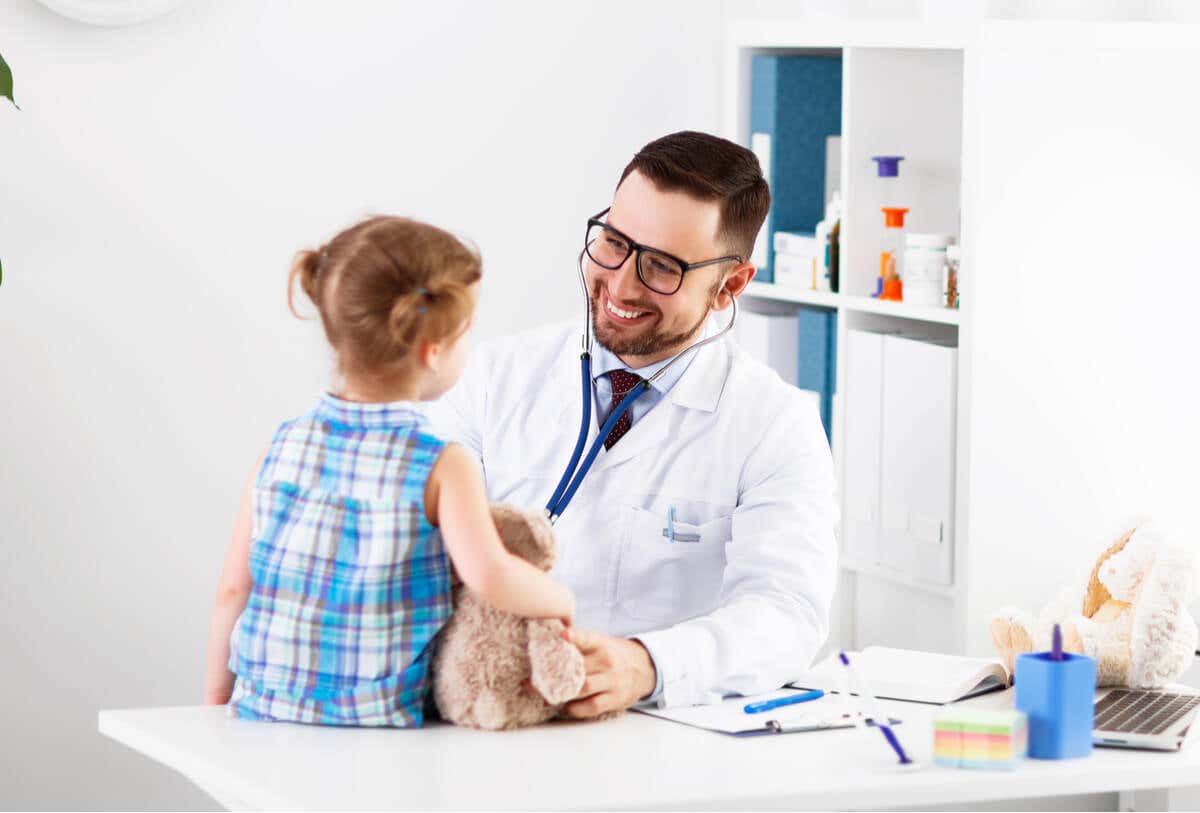 Pediatra en konsultasjon med medisin om niña que nació con hipotiroidismo congénito.