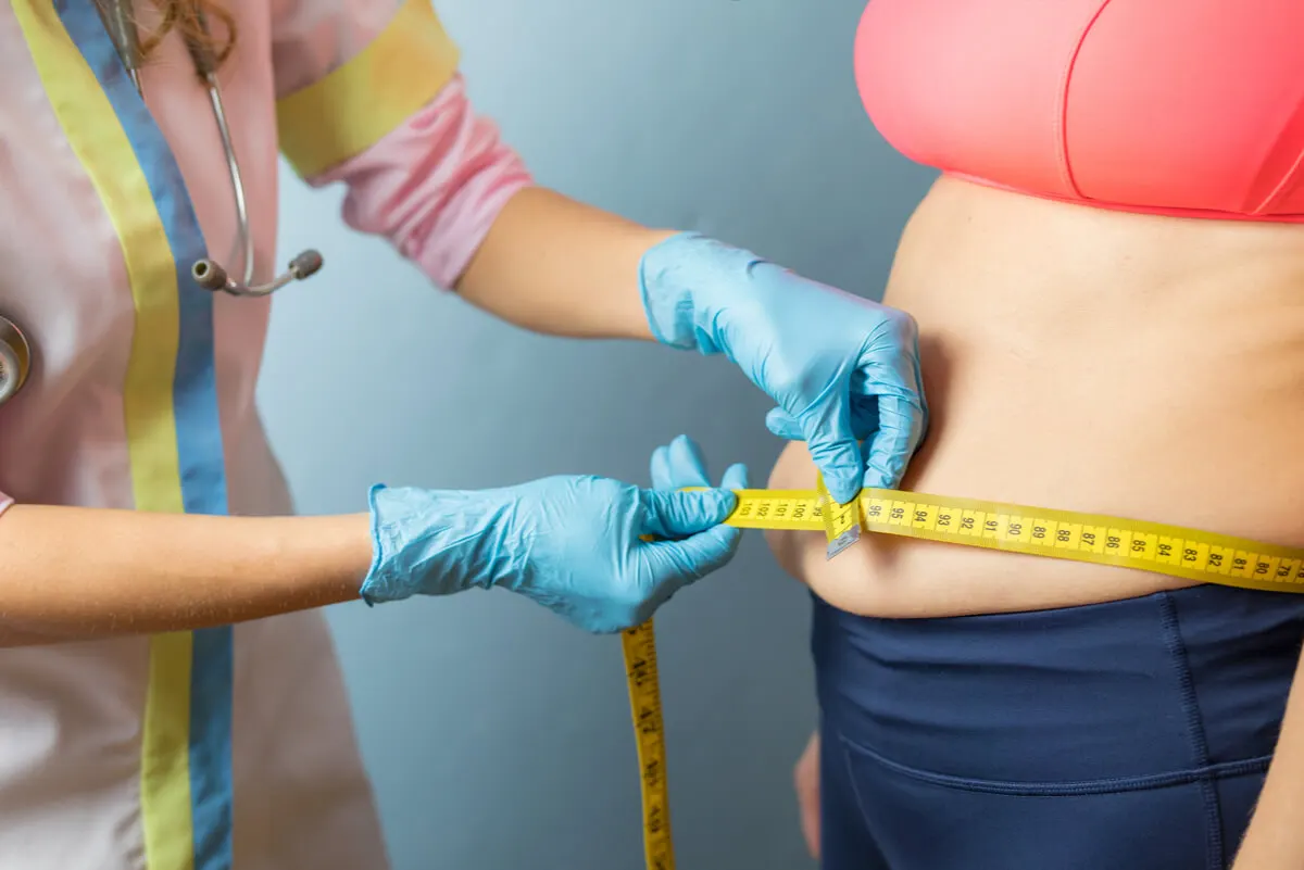 Médica mide el abdomen de paciente