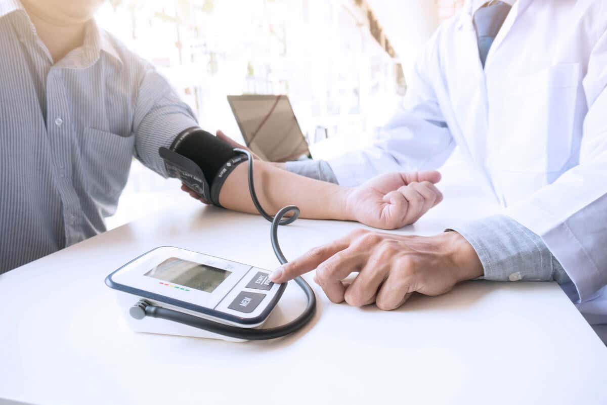 Médico mide la presión arterial.