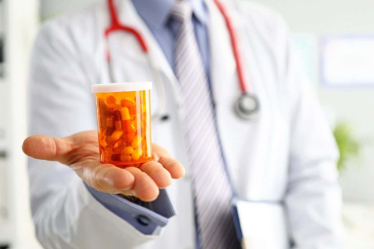 Medico con frasco de antibióticos