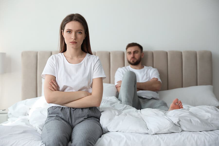 Pareja con problemas peleada en la cama.
