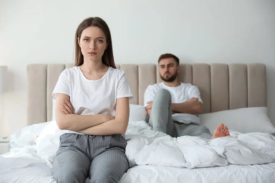 Pareja con problemas peleada en la cama.