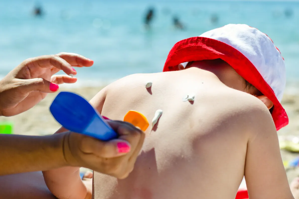 Fotoprotección solar para un niño en la playa.