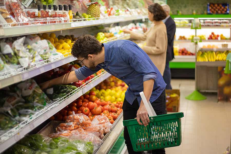 Hombre eligiendo verdura en el supermercado.