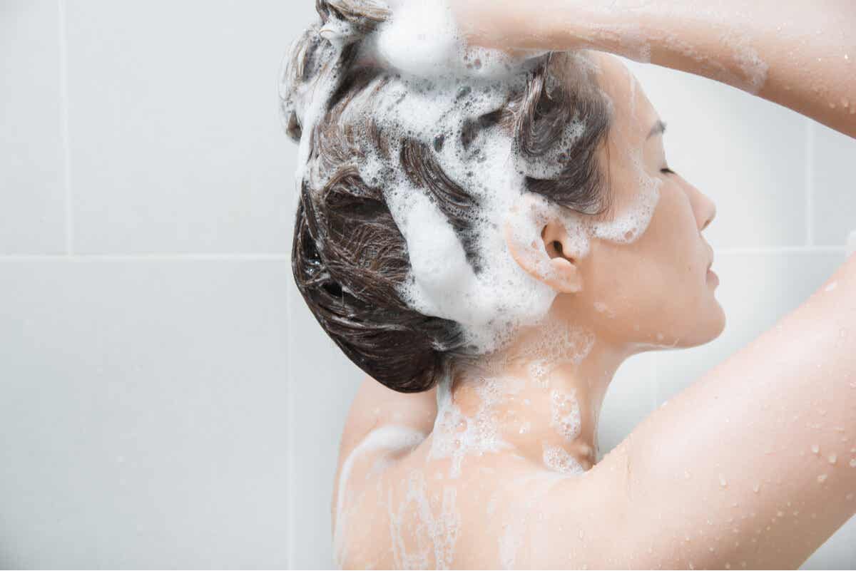 La femme utilise du shampoing pour ses cheveux.