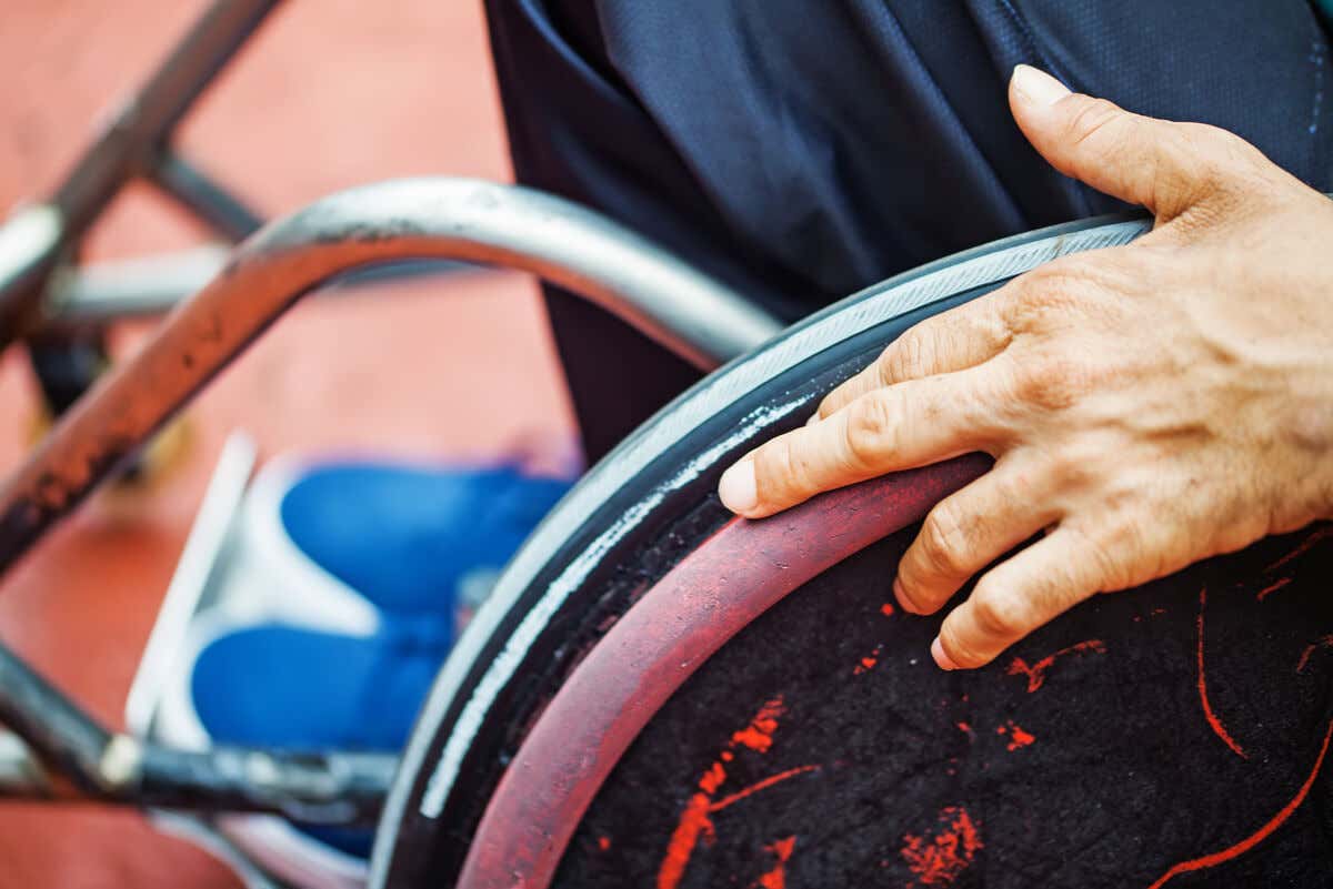 Persona en silla de ruedas por poliomielitis.